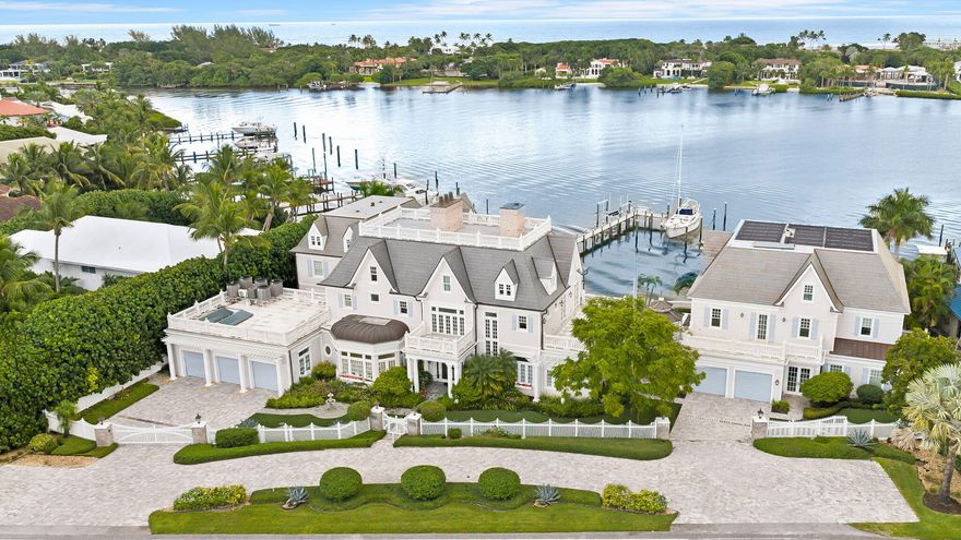 Introducing Anglesea Estate, a waterfront residence where timeless European architecture meets modern coastal luxury along Jupiter's Intracoastal Waterway. Recently repositioned and now offered under appraised value, this extraordinary property presents a rare opportunity to acquire a legacy waterfront estate among Jupiter's most significant properties. Completed in 2016, the residence commands 200 feet of elevated Intracoastal frontage, offering sweeping water views and a rare combination of waterfront presence and flexibility seldom found in Jupiter. Designed as a multi-structure waterfront compound, Anglesea Estate blends classic craftsmanship with contemporary sophistication for a distinguished South Florida lifestyle.  Inside, exceptional craftsmanship is evident throughout, from custom millwork and beautiful stained glass accents to an exquisite hand-carved Carrara marble fireplace, Murano chandeliers, and refined architectural details. The chef's kitchen is designed for both entertaining and everyday living, featuring premium appliances and dual walk-in pantries. The primary suite serves as a private retreat, complete with its own fireplace, dual spa-inspired en-suites, and expansive walk-in closets. Additional bedroom suites open to broad terraces overlooking the Intracoastal, while a three-story elevator provides effortless access throughout the home. Outdoor living is equally impressive. The covered veranda features retractable hurricane and insect screens and opens to a heated pool and spa powered by both solar and electric systems. A 1,000-gallon buried propane tank, whole-home generator, and advanced lightning and surge protection provide added peace of mind. For boating enthusiasts, the 140-foot private dock with a 16,000-pound lift sits along a quiet no-wake stretch of the Intracoastal with direct access to the Jupiter Inlet and Atlantic Ocean. Anglesea Estate offers exceptional flexibility. In addition to the main residence, the property includes a separate two-story guest house with an open concept three bedrooms and two baths, along with family/game room, a full kitchen, laundry, and a two-car garage. Above the guest house, a private professional office suite with kitchenette and one-and-a-half baths creates an ideal live-work environment. The 1,250-square-foot Captain's Quarters provides additional flexibility with plans available to convert the space into another waterfront living suite. The property also benefits from both residential and commercial zoning designations, no HOA, offering rare optionality for a private executive compound, family office, or luxury live-work estate. Located moments from Jupiter Hills Golf Club and many of South Florida's premier PGA-caliber golf courses, Anglesea Estate offers the flexibility and waterfront presence typically found only in Palm Beach compound estates. With 200 feet of Intracoastal frontage, and now offered under appraised value, Anglesea Estate represents a rare opportunity to secure one of Jupiter's most exceptional waterfront properties.