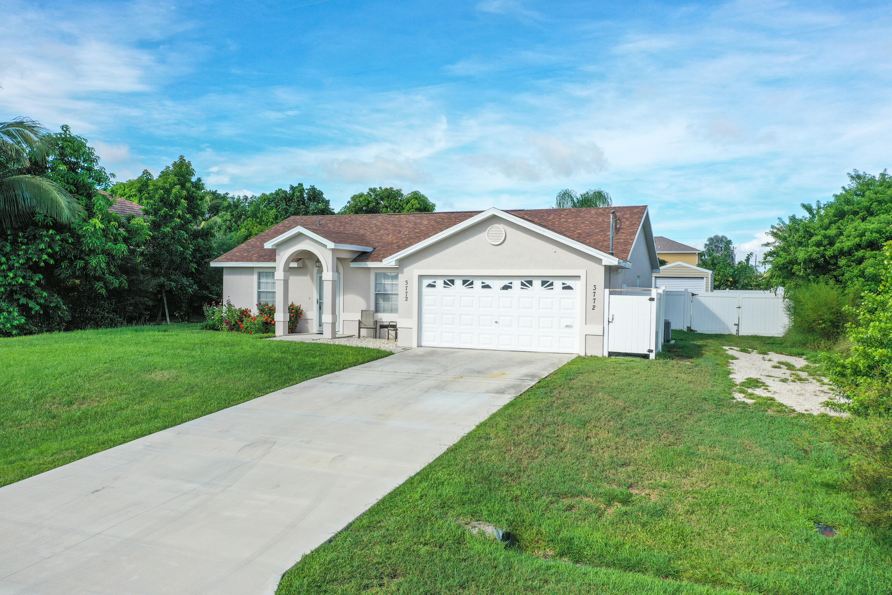Welcome Home to this meticulously cared for 3BR, 2BA, bright, spacious home with large master suite & walk-in closet. Laundry room w/ front load W/D. Like new kitchen appliances. Nestled in a lovely, quiet and friendly PSL neighborhood with NO HOA. Your family will enjoy Large Screened Porch ideal for outdoor gatherings and fenced in yard with mature fruit trees. This property also features a large workshop/storage shed and 2-car attached garage w/ ample driveway and side parking. Come see this lovely move in ready, freshly painted interior/exterior home with beautiful laminate flooring. Enjoy piece of mind with a NEW 2025 roof, 2024 H/W heater, regularly maintained A/C. Close to schools, parks and shopping. Easy access for commuters to both I-95 and Turnpike. Schedule your showing toda