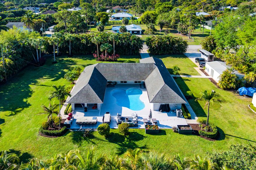 Welcome to this exceptional Wellington residence offering refined comfort, privacy, and effortless living. Set on a vast, private lot highlighted by a grand mango tree, this home features a thoughtfully designed split-bedroom floor plan that blends functionality with an inviting, airy feel. The outdoor living is truly spectacular, with a resort-style pool and an expansive summer kitchen ideal for elevated entertaining. Equestrian enthusiasts will appreciate the tack room and prime location. Enjoy newly renovated baths, a warm and inviting fireplace, and an open-concept layout. Pet-friendly with no HOA, and ideally located near exceptional schools with seamless access to 441 and the Florida Turnpike. A must-see offering the best of Wellington living.