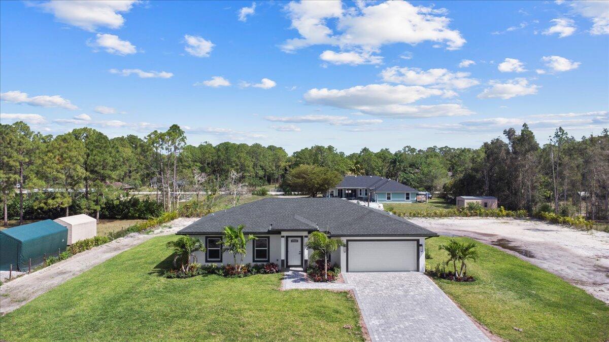 Welcome to your brand-new 2025 construction in the highly sought-after community of Loxahatchee! This 4-Bedroom, 2-Bath home sits on a spacious 1.14-acre lot, offering the perfect blend of luxury and functionality. Built with full-impact windows and doors, it features immaculate finishes throughout! The gourmet kitchen showcases an oversized island with elegant quartz countertops, complemented by 32''x 32'' luxurious porcelain tile flooring and soaring vaulted ceilings. Enjoy pristine, clean water in every room, thanks to the whole-house reverse osmosis system. With Plenty of space and versatile layout, this property offers endless possibilities - whether for your personal enjoyment or to accommodate a home-based business! Schedule you private tour today!