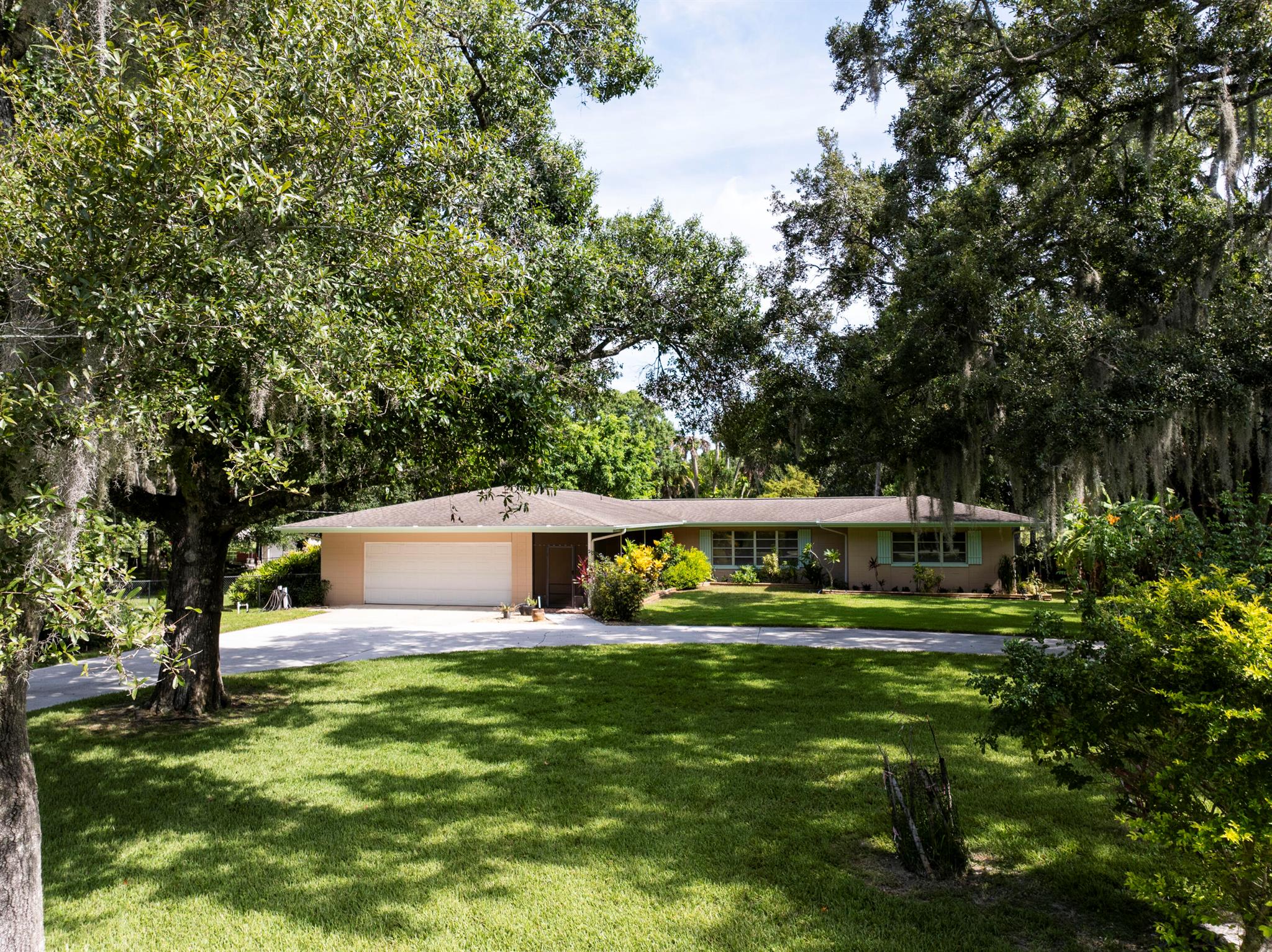 Charming Mid-Century CBS home on 1.76 acres- Old Florida Hammock Setting.Nestled beneath a lush canopy of mature oaks and cabbage palms, this solid concrete block (cbs) 3 bedroom, 2 bathroom home offers timeless character and unbeatable tranquility. Set on 1.76 acres of natural Old Florida Hammock, the property is shaded by a mix of native large oaks and cabbage palm trees offering a private setting rarely found today. Inside, the home retains its mid-century charm with solid construction a spacious layout and overside 2 car garage with a circle drive way for ample parking and storage. The rear of the property also provides a large 20 x 22 workshop for projects, hobbies, or extra storage along with a second smaller shed for added storage. Home is on city water with septic.