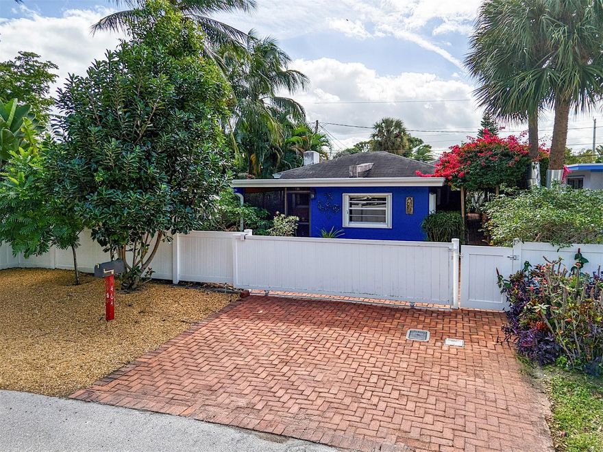 Discover one of the sweetest locations in Wilton Manors. Truly walkable to grocery, CVS, and more. Leave your car behind the rolling privacy gate & stroll to Starbucks, Storks Bakery or the Mexicana Taco Bar. This lovely 3 bedroom, 2 bath home is nestled within a beautiful curated garden and surrounded by paths of Chicago brick. The  brick patio in back is shaded by a retractable awning for dining or relaxing. Enter the home through the comfortable screened patio, cooled by surrounding foliage. Kitchen, dining area and living room flow nicely into each other & laundry room is directly off of the kitchen. A bedroom and en-suite bath is in the front of the home, an additional 2 bedrooms are in the rear. Split plan affords privacy and flexibility. Come and see this "cottage in Wilton Manors"