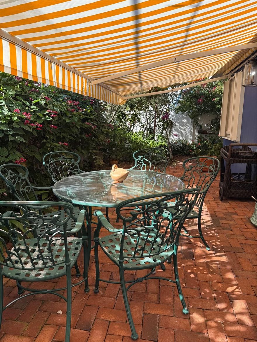 Discover one of the sweetest locations in Wilton Manors. Truly walkable to grocery, CVS, and more. Leave your car behind the rolling privacy gate & stroll to Starbucks, Storks Bakery or the Mexicana Taco Bar. This lovely 3 bedroom, 2 bath home is nestled within a beautiful curated garden and surrounded by paths of Chicago brick. The  brick patio in back is shaded by a retractable awning for dining or relaxing. Enter the home through the comfortable screened patio, cooled by surrounding foliage. Kitchen, dining area and living room flow nicely into each other & laundry room is directly off of the kitchen. A bedroom and en-suite bath is in the front of the home, an additional 2 bedrooms are in the rear. Split plan affords privacy and flexibility. Come and see this "cottage in Wilton Manors"