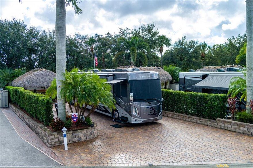 2,958SF RV lot is comfort, style, & functionality in a premier Class A-only gated communities, the Motorcoach Resort St. Lucie West, the property is a fully pavered pad, Eisenglass roll-down enclosure Tiki hut w/ AC, & outdoor kitchen along w/ a grill, furniture & mounted TV, Move-in Ready. Tropical landscaping & hedges provide privacy; a spacious layout allows for expansion/personalization. Residents have access to 4 resort-style pools w/ spas, tennis, pickleball, fitness center, 18 hole Golf Course, dog parks & much more. The renovated clubhouse hosts socials, holiday celebrations, & themed gatherings. Near shopping, dining, & entertainment, ¼ mile from Clover Field Mets Stadium. This is great for both seasonal & long-term investment. 2020 Thor Venetian R40 also avail for $249,000 Cable, internet, water, sewer and trash are included in the HOA fees. Golf cart available for sale.