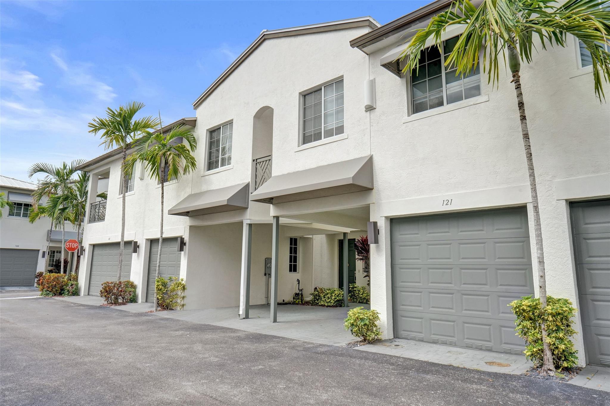 Gorgeous 3 bed/2.5 bath, 2-story townhome with high-volume ceilings in a highly desired gated community, just 6 mins from the beach. The primary suite features two walk-in closets and a spacious bath. Highlights include large kitchen w/ granite counters, lots of cabinet space, brass accent handles/lighting, SS appl, white porcelain 24x24 tile throughout main floor, high-quality water resistant laminate on the 2nd floor, a sleek glass and steel staircase, impact windows and doors, and a lovely back patio/yard just off the kitchen and dining area. Parking includes a 1-car garage plus a covered carport. With new restaurants, entertainment, and waterfront projects underway, Pompano Beach is rapidly transforming making this home not only a perfect lifestyle choice but also a smart investment.