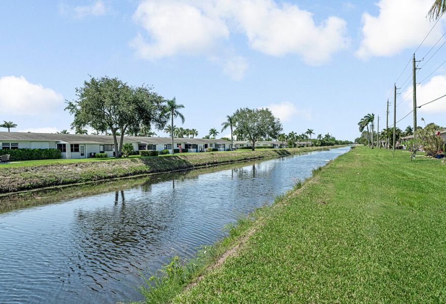 Affordable, well priced, cozy 2-bedroom, 1-bathroom home featuring tile flooring throughout and a open backyard with a peaceful canal view. Enjoy the convenience of hurricane shutters, plenty of storage, and a dedicated parking spot just steps from your front door. The low monthly condo fee covers water, lawn care, cable, and internet. Located in the desirable 55+ community of Dudley, residents enjoy access to a clubhouse, pool, sauna, fitness center, auditorium, shuffleboard and horseshoe courts, billiards room, workshop, and a full calendar of activities. Perfectly situated in the heart of Palm Beach County—just minutes from shopping, dining, entertainment, and Palm Beach International Airport.
