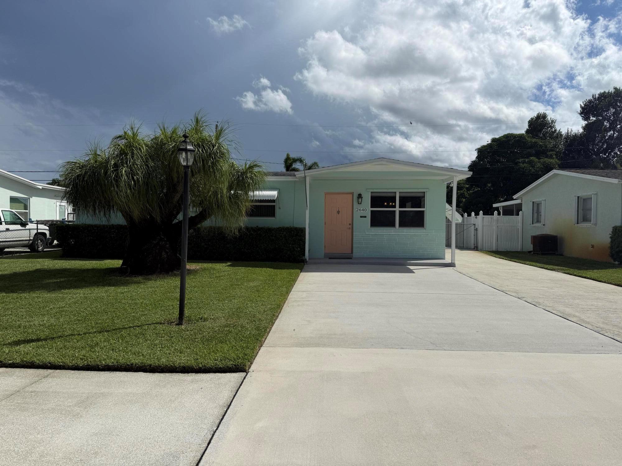 Welcome to this charming 3-bedroom, 1.5-bathroom home, perfectly situated just minutes from downtown, Palm Beach Airport, & the local beaches! Inside, you'll find modern tile flooring throughout, an updated kitchen with newer appliances, & the convenience of an in-home washer & dryer. Both bathrooms have been tastefully renovated, adding a fresh, modern touch. Step outside to enjoy the large screened-in patio with a ceiling fan, ideal for relaxing or entertaining. After a day at the beach, refresh with the outdoor shower. The fully fenced backyard features two storage sheds for tools, toys, or hobbies, while the spacious driveway & covered parking add both practicality & curb appeal. This move-in-ready home offers comfort, style, & an unbeatable location, making it the perfect home!