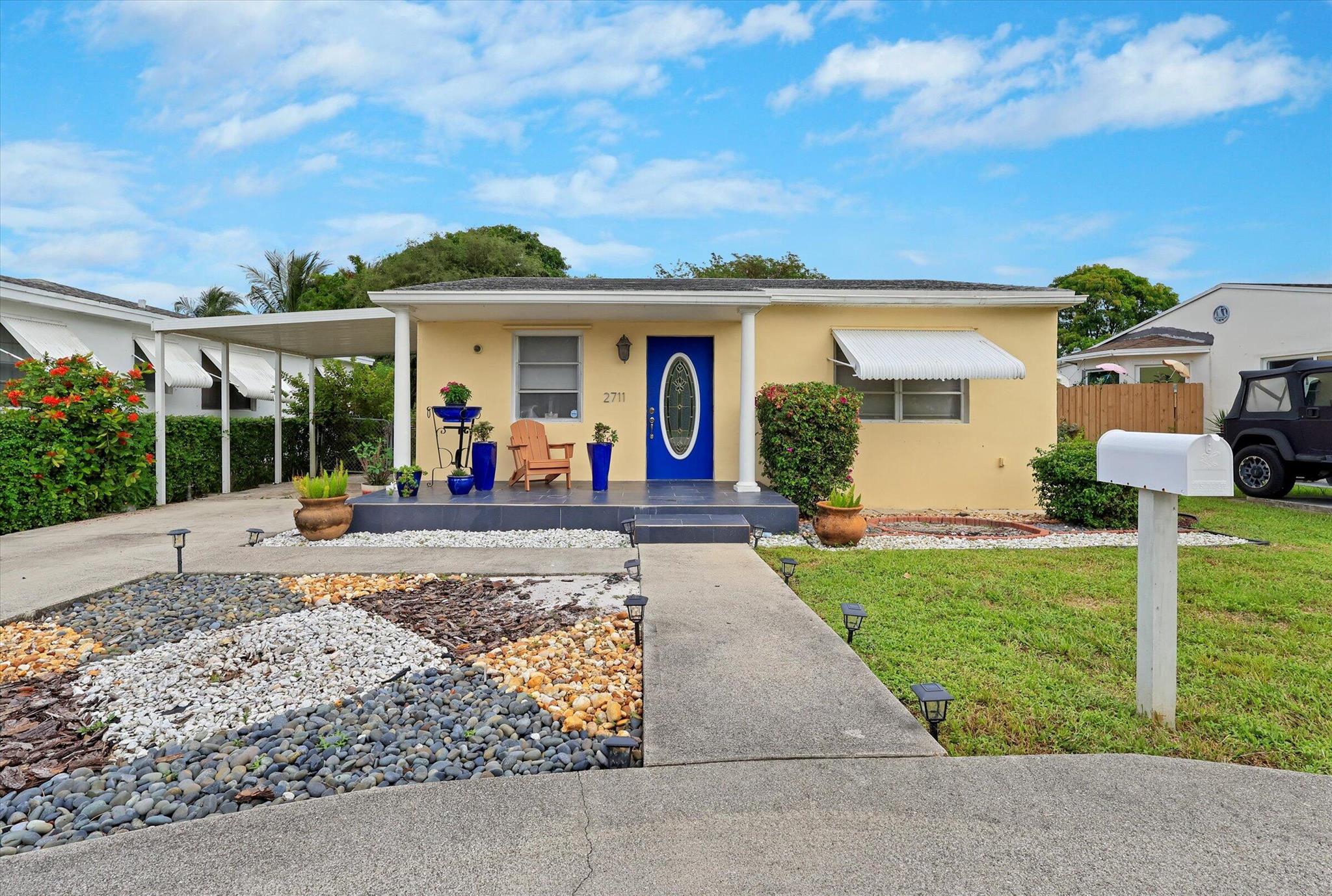 Huge tropical yard with fruit trees. White kitchen with an island and quartz counters. Very large master bedroom with great closet space Screened porch with utility room and BBQ area. Electric awning. Circular driveway. Bonus separate room/office.