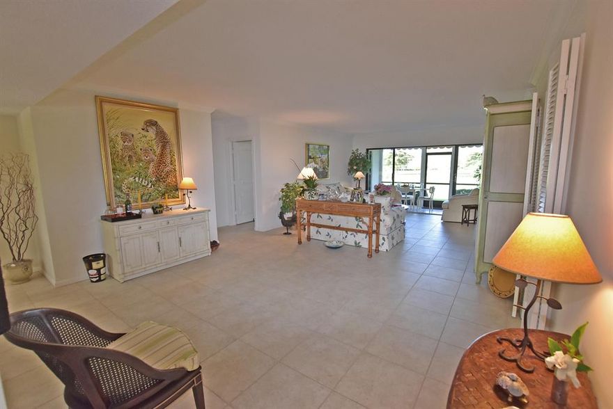 Ideal locale comes with this impressive garden residence offering scenic lake and golf course view. Located on the first floor you have an open patio by the entry, sliders provide access to the kitchen area. Enter through the front door into a spacious interior, neutral tile flooring, crown molding & fantastic view. Just off the living room is your screened porch-sit back, enjoy the view & the wonderful Florida breezes. The third bedroom is being used as a den but easily converted back to a bedroom if needed. Updated kitchen has cream color cabinets, beige counter top & stainless appliances. Kitchen terrace area has been leveled & opened to kitchen and has impact glass sliders. Master bath has dual sinks & walk-in shower. Easy to love, Easy to live in! Furnished-artwork & armoire excluded. Mandatory membership. Quail Ridge is a private, member-owned community and club. All residents are members of The Club at Quail Ridge and have a choice of Full, Intermediate or Primary Membership.