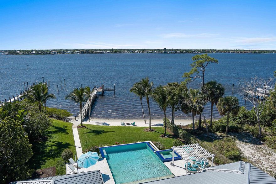 Accepting all offers.  Enjoy waterfront living in this 2017 custom estate, now offered at a new reduced price. Privately set behind gates on nearly an acre, the residence was designed to capture sweeping views of the St. Lucie River while blending comfort, elegance, and sophistication.Inside, you'll find six spacious bedrooms, two private offices, 4.5 baths, a 4.5-car garage, & a versatile guest or in-law suite. Soaring ceilings, a sleek metal roof, and seamless indoor-outdoor flow showcase Florida's signature style.Enjoy resort-level living with a spectacular infinity-edge saltwater pool, spa, sun shelf, fully equipped summer kitchen, generator, and your own private sandy beach. Nearly 115 feet of pristine waterfront with a deep-water dock and 20,000-pound lift accommodates ya