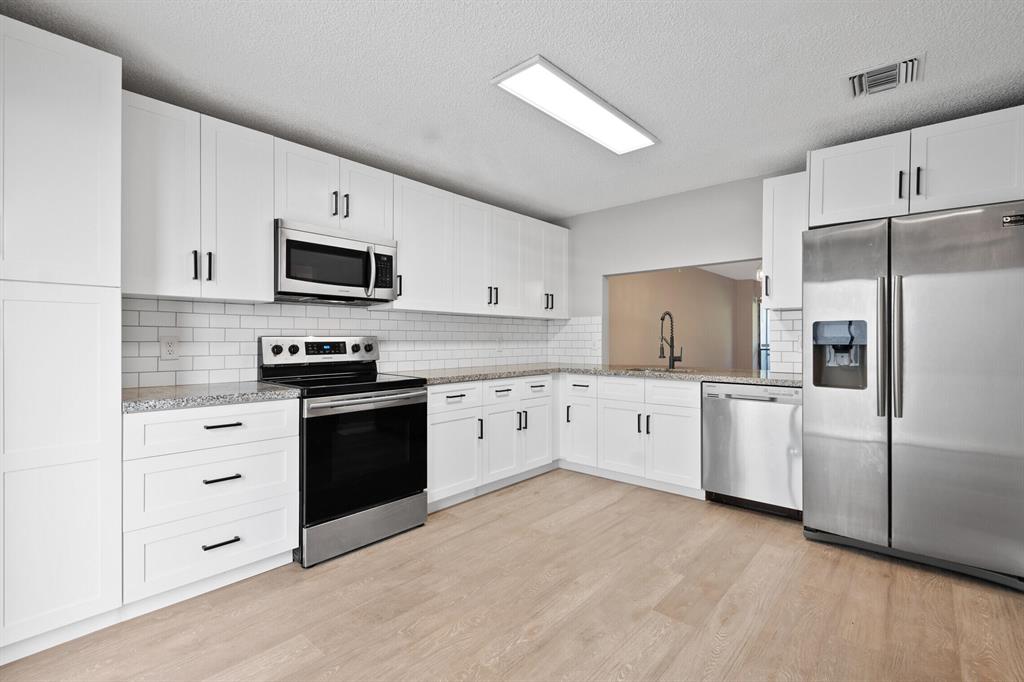 Beautifully Remodeled Townhouse with a New Roof along with New white shaker kitchen cabinets, white subway tile backsplash, granite and stainless appliances. Both bathrooms upstairs have been remodeled. There is laminate flooring throughout including on the stairs and NO carpet. Master bath has dual sinks and Master bedroom has a 12 x 6 walk in closet. The first floor has a 1/2 bath, kitchen, Great room and dining room. Large screen patio out back with a storage area. Washer and dryer is upstairs in the hallway closet. There are panel hurricane shutters. minutes to the Florida Turnpike. All room sizes are approximate. Don't miss this one