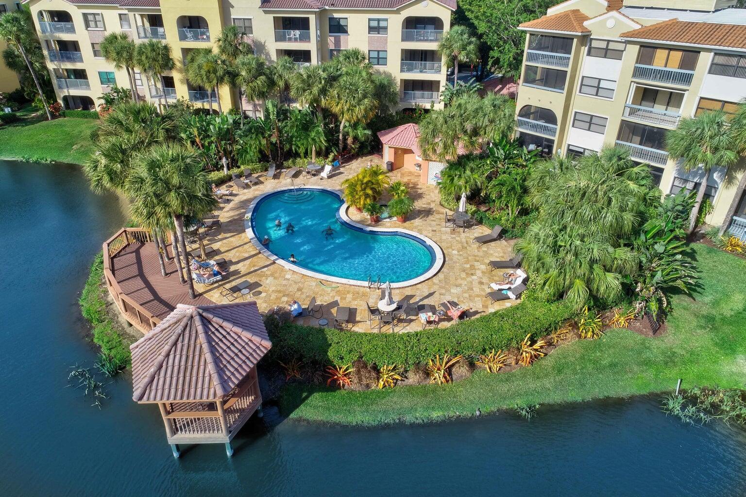 Spectacularly remodeled 4th-floor condo with southern exposure and peaceful lake views from your private balcony! Features include quartz countertops, custom cabinetry, luxury vinyl flooring, and newer stainless appliances. The primary offers a king bed and 52'' smart TV; second bedroom includes a queen Murphy bed, plus a queen sleeper sofa in the living room with 62'' smart TV and surround sound. Located in a gated community with 2 pools, Jacuzzi, and fitness center. Just minutes to beaches, boating, golf, Downtown Gardens & dining. Covered parking space #48 included.