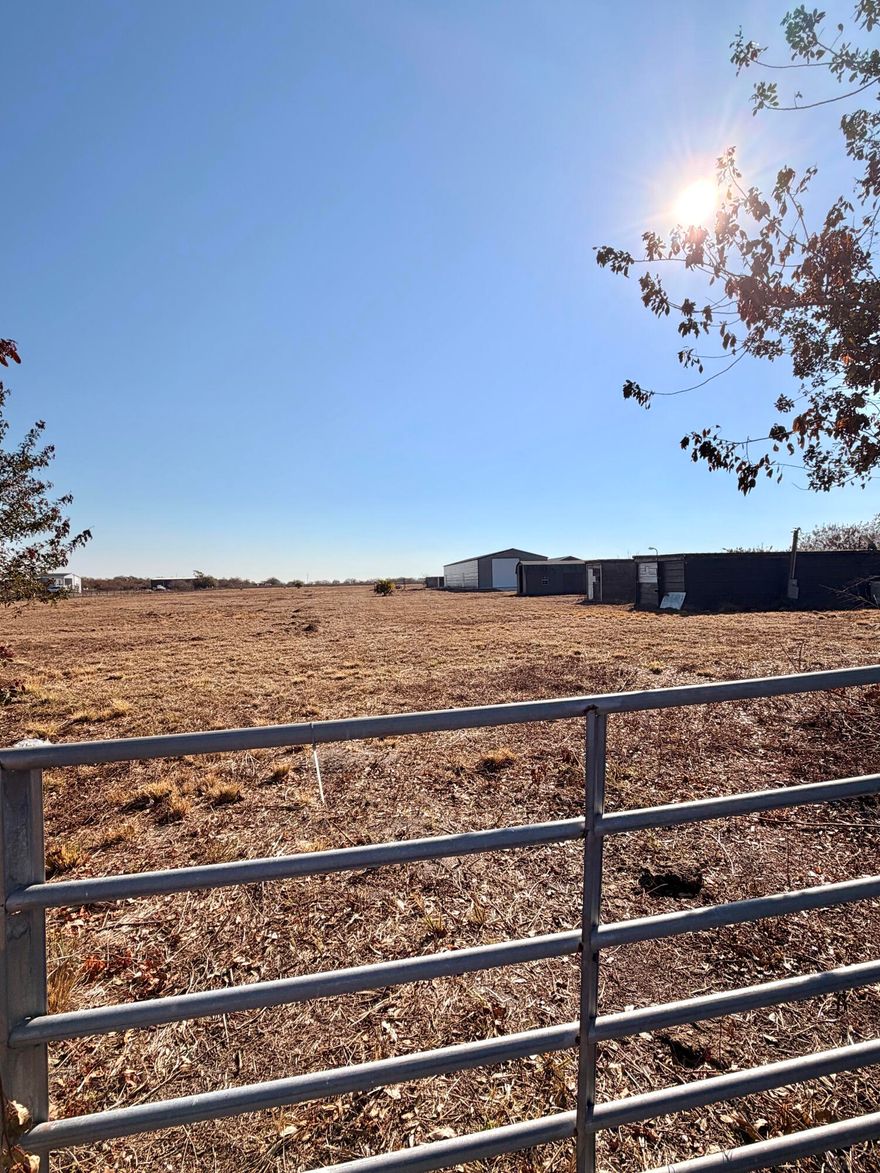 10 acres of cleared land featuring a large metal workshop with electric, two sheds, and two storage containers. Property includes a well and electric already in place, offering a strong head start for building, business use, or storage. Versatile acreage with endless potential. Fenced and gated.