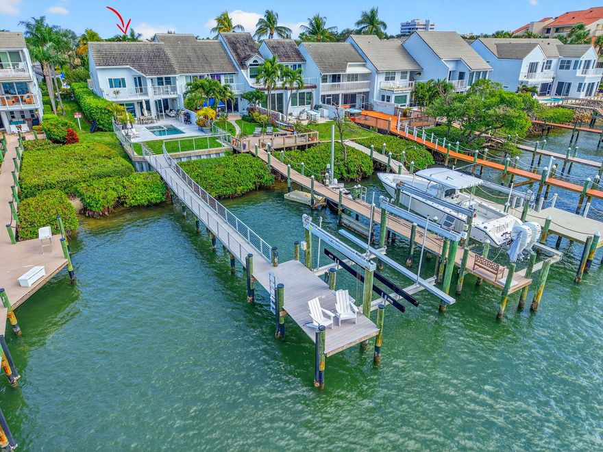 An exceptional end-unit, direct Intracoastal offering in gated Jupiter Harbour, delivering a caliber of waterfront living rarely achieved at this price point. This 3-bedroom, 2.5-bath residence offers distinguishes itself with a private rear yard, heated pool, outdoor kitchen, private dock with water and electric, and a 24,000 lb boat lift—features that are extraordinarily scarce within the community and at this precedent. Enjoy deep-water boating with no fixed bridges to the Jupiter Inlet, impact windows and doors, an updated roof, and multiple AC systems including a climate-controlled two-car garage. The end-unit configuration enhances privacy, natural light, and outdoor living. Walkable to dining, marina services, and the Jupiter Riverwalk. A rare opportunity