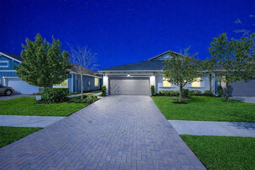 Welcome to Arden, one of Palm Beach County's newest and most sought-after communities. Built in 2023, this beautifully upgraded 3-bedroom, 2-bath ranch-style townhouse offers the ease of single-level living, a desirable split-bedroom floor plan, and a private fenced backyard that creates the feel of a single-family home with the convenience of townhouse living.  Step inside to a bright and welcoming interior designed for both comfort and functionality. The open-concept living and dining areas flow seamlessly together, highlighted by custom lighting fixtures, new carpeting throughout, and a stylish ceiling fan in the living room. Sliding glass doors lead to the backyard and are enhanced by a remote-controlled blinds for added convenience and privacy. The kitchen offers modern appliances and ample cabinetry, while the adjacent dining space features upgraded pendant lighting that elevates the home's contemporary feel. The primary suite provides a comfortable retreat with generous closet space and a well-appointed ensuite bath. Two additional bedrooms are thoughtfully positioned on the opposite side of the home, creating privacy for family or guests and flexibility for a home office or hobby space. Throughout the home, custom 2-inch wood blinds add a polished, cohesive look. Outdoor living is equally appealing with a fully fenced backyard, offering space to relax, entertain, or enjoy pets. Additional enhancements include an irrigation filter for the backyard system and an epoxy-coated garage floor, creating a clean and durable finish. Additional upgrades include new carpet throughout, custom lighting fixtures, LG washer and dryer, remote slider blind, wood blinds throughout, irrigation system filter, and epoxy garage flooring, reflecting the care and investment the sellers have made in the home. Residents of Arden enjoy a unique agrihood lifestyle centered around community and outdoor living. Amenities include a resort-style pool, clubhouse, fitness center, tennis and pickleball courts, scenic lake with dock, picnic areas, and the renowned Barn & Garden, where residents can grow and harvest their own produce. Ideally located in western Palm Beach County, Arden offers convenient access to shopping, dining, parks, and major roadways while maintaining a peaceful, nature-focused setting. Sellers are motivated — schedule your private showing today and take advantage of this beautifully upgraded home before it's gone.