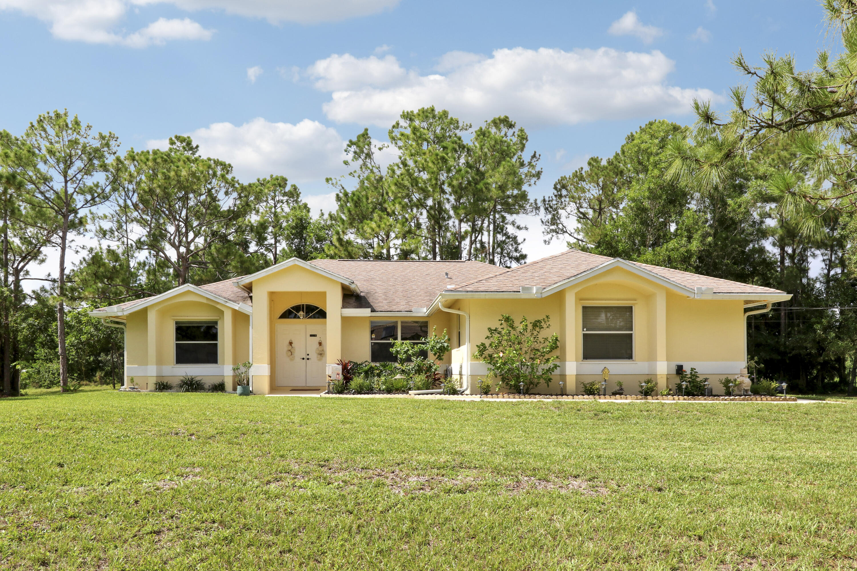 Welcome to 18854 48th Avenue N, Loxahatchee a charming residence nestled in the serene community of Loxahatchee, FL. This inviting property offers a rare opportunity to own a home on 1.29 acres with no HOA restrictions, providing ample space and freedom to create your ideal living environment. Spanning 1,615 square feet, this home features a thoughtful split-bedroom layout with three bedrooms and two bathrooms, ensuring privacy and comfort for all occupants. The spacious kitchen is a culinary enthusiast's dream, equipped with granite countertops and a convenient island that enhances both functionality and style. The primary suite serves as a tranquil retreat, offering a peaceful haven for relaxation. Many exotic fruit trees in the backyard-papaya, jack fruit & soursop & butterfly garden!