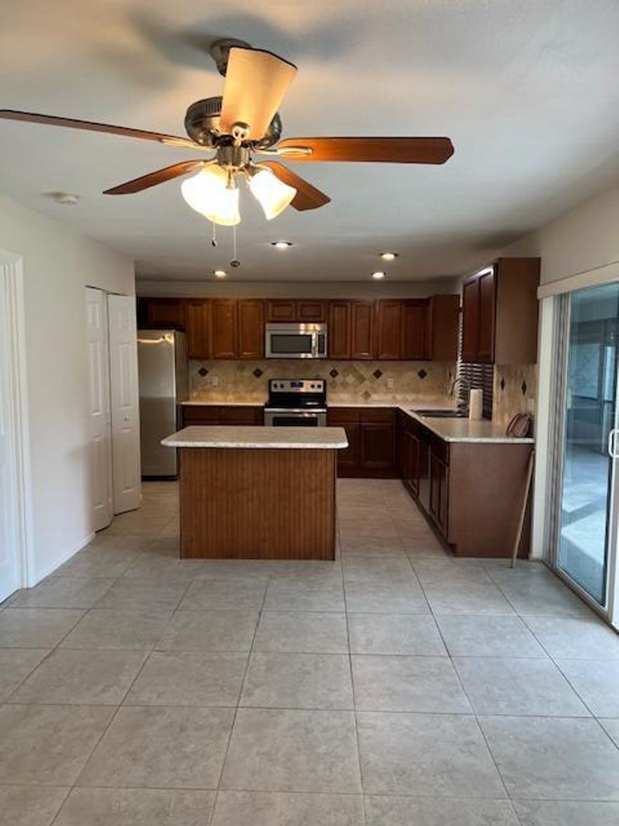 Don't miss out on this wonderful opportunity! This spacious single-family home in Royal Palm Beach offers a 2-car garage and a generous backyard--perfect for enjoying Florida living. You'll love being just a short walk from Commons Park, where you can catch concerts, events, and the always-popular Saturday Green Market.Inside, the home has been freshly painted and features an updated kitchen with granite countertops, a large pantry, and a center island. The huge 24x12 primary bedroom includes his-and-hers closets, dual sinks, and sliding doors that open to the expansive screened patio.With tile flooring throughout (no carpet!), impact windows, and an amazing 35x10 screened patio off the kitchen, this home is truly move-in readyOpportunities like this don't last--make sure to see