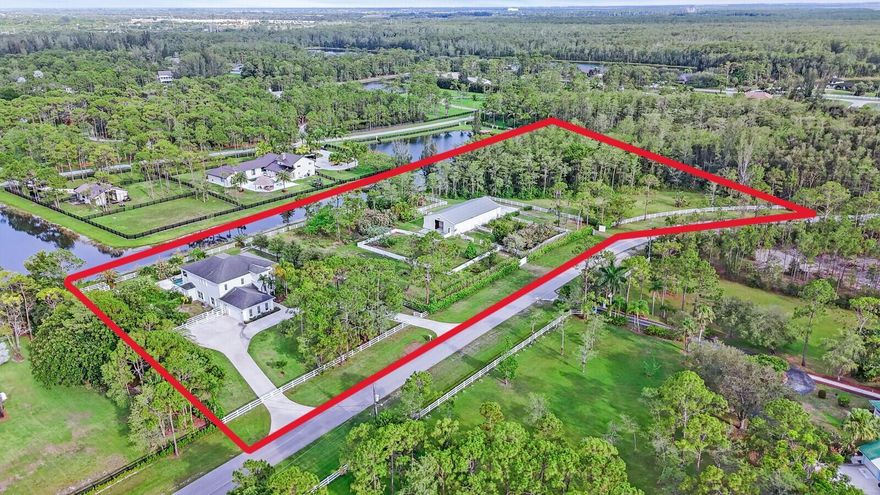 6688 Duckweed Road, Lake Worth, Florida 33449 In The Prestigious Equestrian, Guard-Gated Community Of Homeland, Renowned For Its Secluded Charm, Is Set On More Than Five Sprawling Lakefront Acres And Encompasses A Five Bed / Four Bath Main House And Five Stall Barn Replete With Tack Room, Twin Offices And RV Garage. Designed With An Appreciation For Spaciousness, This Two-Story, Horse-Friendly Home Offers A Blend Of Tranquility, Comfort And Serene Countryside Living Along With Recently Updated Flooring, Bathrooms, Appliances, Cabinetry and Counter-Tops. An Abundance Of Large Windows Throughout The Property Maximize Natural Light While Providing Picturesque Views Of The Surrounding Greenery And Numerous Separately Enclosed Horse-Grazing Corrals - Embodying An Exceptional Equine Lifestyle.