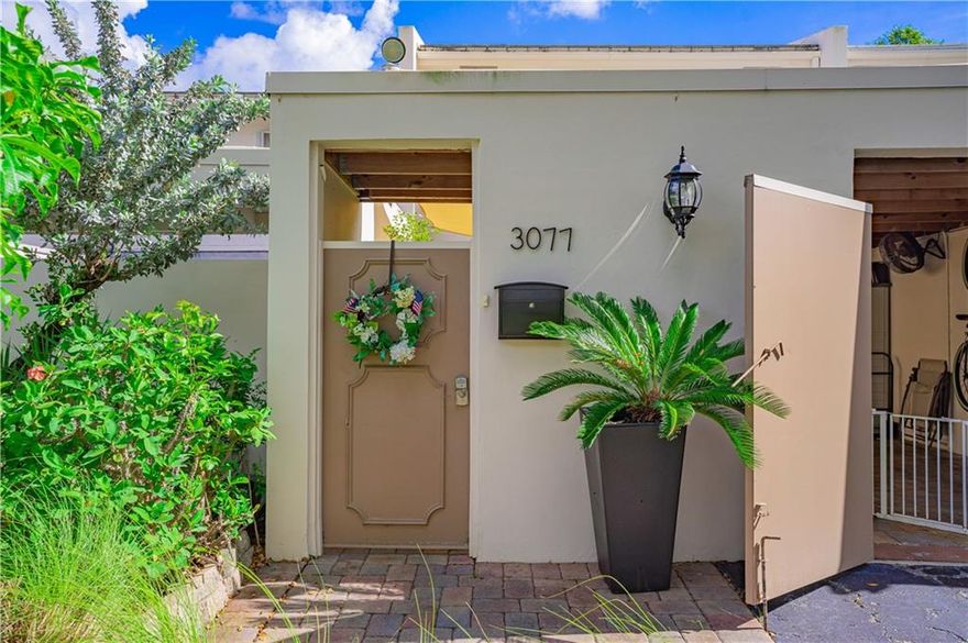 Desirable opportunity to own a redesigned townhome that truly embodies the South Florida lifestyle. Tropical oasis as you walk into your secured covered carport with lush foliage & outdoor shower. Outfitted with a gourmet chef's kitchen, extra freezer, & high-quality appliances. Top of the line built-ins furniture with lifetime service, custom flooring & lighting, with plantation louver doors throughout. Owner's suite with magnificent views of lake, custom closet, electrical blinds, spa-bathtub & glass shower. Step out into your open balcony as you look over your custom backyard for great entertaining with outdoor lighting.  All hurricane impact windows & sliding doors. Tankless water heater & A/C less than 5 years. Spacious Screen-In Porch. New roof to be installed soon. All Ages Welcome.