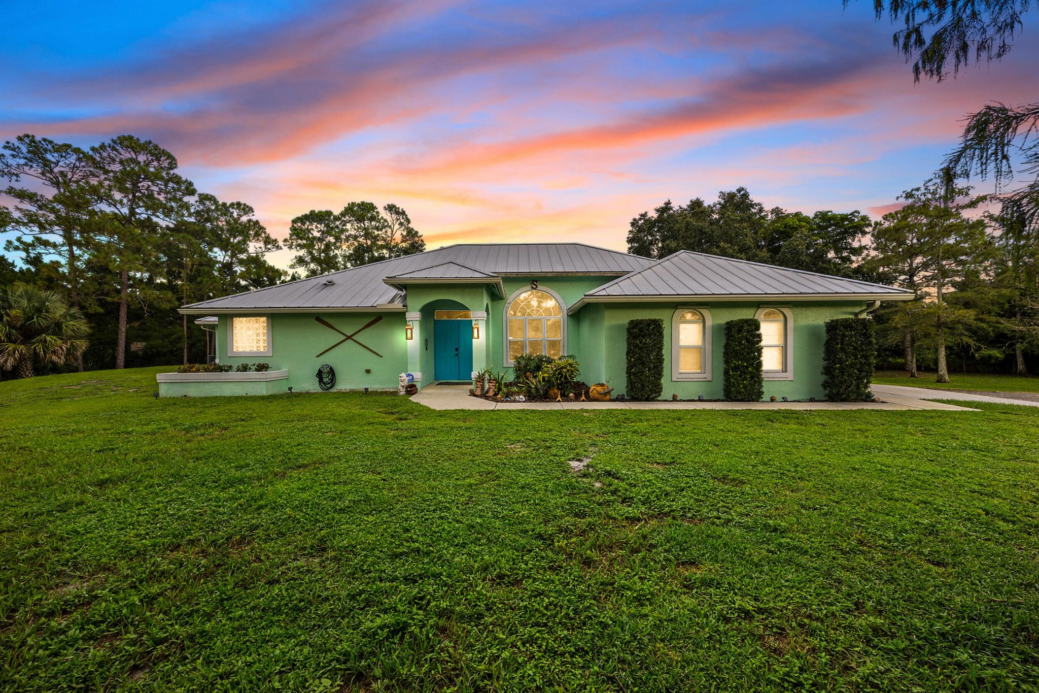 Nestled on a spacious corner lot on 1.39 acres this home exudes the quintessential Acreage lifestyle--where expansive properties meet a rural, equestrian-friendly vibe, offering residents the freedom of larger lots, proximity to nature trails, and a peaceful escape from urban hustle while still being conveniently close to West Palm Beach amenities. This stunning 3-bedroom, 2-bath main home with a 900 square foot 2 bedroom 1 bath guest house built in 2019. The main house features a thoughtful split plan design with soaring vaulted ceilings that enhance the sense of openness and light. The heart of the home is an inviting open-concept kitchen boasting stainless steel appliances, seamlessly flowing into the living and dining areas--ideal for modern family living and entertaining.