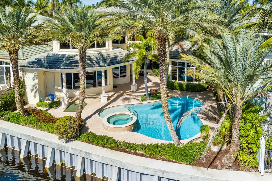 Rarely available in the exclusive Harbour at Jonathan's Landing, this sophisticated custom estate is tucked within an intimate 11-home enclave on a quiet cul-de-sac. Offering 4,840 square feet of refined living space, the residence features four bedrooms, five full baths, and one half bath, thoughtfully designed for both elegance and comfort. Enjoy breathtaking lake views and sweeping vistas of the 13th green of the Village Golf Course from multiple living areas. Boating enthusiasts will appreciate the deeded dock slip accommodating up to a 50-foot vessel, with quick access to the Intracoastal Waterway. The first-floor primary suite provides ease and privacy, with the flexibility for a second primary suite on the upper level. Marble floors grace the entire first floor, while the gourmet kitchen overlooks the family room and opens seamlessly to a stunning outdoor living space complete with an in-ground poolperfect for entertaining or relaxing in the Florida sunshine. Additional highlights include an elevator, wine room, and a three-car garage. All just minutes from the Intracoastal, this exceptional waterfront estate offers a rare blend of luxury, privacy, and lifestyle.