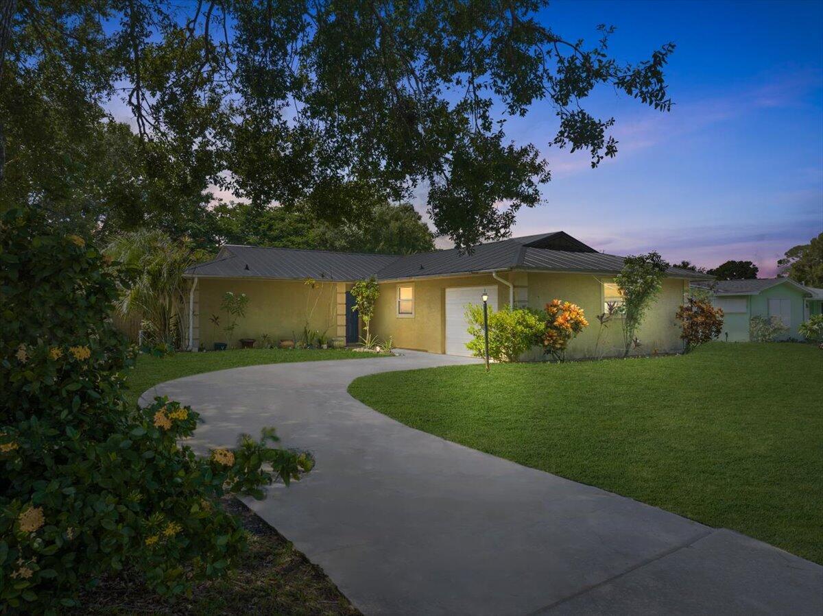 Plenty of room for boat, RV, and other toys with extra long driveway and no mandatory HOA! Step inside this charming home in the sought-after Lakewood Park community. This well-maintained home offers an open and airy living room with vaulted ceilings, creating a bright and spacious feel. The kitchen flows seamlessly into the dining and living areas, making it perfect for entertaining. Enjoy Florida living year-round from the screened back porch, overlooking a fully fenced backyard that offers privacy and space for pets or gardening. The metal roof, tile flooring throughout, and stucco exterior provide peace of mind and low maintenance. Located on a quiet street, this home offers a serene setting while still just minutes from shopping, dining, and beaches.