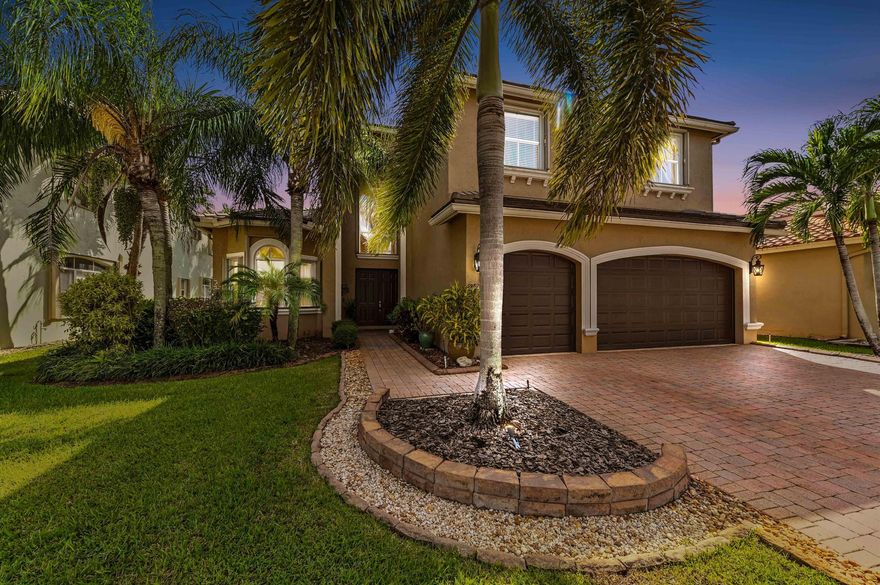 Welcome to this stunning, executive pool & waterfront home, perfectly situated in the highly sought-after, Journey's End community in Lake Worth.  NEW ROOF & AC UNIT!!! The luxury begins the moment you pull up the paver driveway, framed by lush tropical landscaping and a beautiful 3-car garage with arched doors. Step inside to a grand, two-story foyer where you are greeted by rich, dark wood-look flooring and elegant wainscoting that lines the beautiful staircase. The main level is designed for sophisticated entertaining, featuring a formal dining room defined by a sparkling crystal chandelier and tasteful trim work.