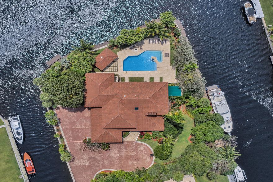 This is a truly exceptional opportunity to own a private, gated point lot waterfront Estate along the South Fork of the New River, offering approximately 540+/- feet of deep-water frontage and no fixed bridges, ideal for large vessels and premier yachting. Overlooking the Secret Woods Preserve, ensuring a serene natural backdrop and long-term privacy, enhancing the feeling of a secluded waterfront sanctuary. The residence features spacious en-suite bedrooms, each with its own private terrace, along with updated bathrooms, a sauna, elevator, and dedicated laundry room. The primary suite is a standout, offering an expansive private terrace with exceptional privacy and sweeping water views. The home offers generous living spaces, including a living room, family room, and formal dining area,  and for your convenience there is a private elevator.  A beautifully custom designed office offering a functional workspace to work from home.  There is also the potential for a guest apartment, captain's quarters, or nanny suite, offering flexible living arrangements. In summary its all  thoughtfully designed with an open layout that flows seamlessly for both everyday living and entertaining.  A well-appointed gourmet kitchen is positioned to complement these spaces. Outdoor living is elevated by a large resort-style heated saltwater pool, designed for both relaxation and entertaining, complemented by a cabana bath, summer kitchen, and covered terraces, creating a setting that feels like your own private island. A key highlight is the newer wraparound dock, providing extensive continuous dockage and equipped with modern shore power and underwater lighting, ready to accommodate large yachts. Riparian/use of waterway for dockage to the East of the Property (the narrow side canal) DOES NOT CONVEY. The West features one shore power station, while the South dock is equiped with two, providing enhanced capacity for large vessels or multiple Yachts.  Additional features include a 4-car garage with custom built-in, seamless storage. A rare opportunity to own a property that combines privacy, scale, and true yachting capability in Fort Lauderdale.