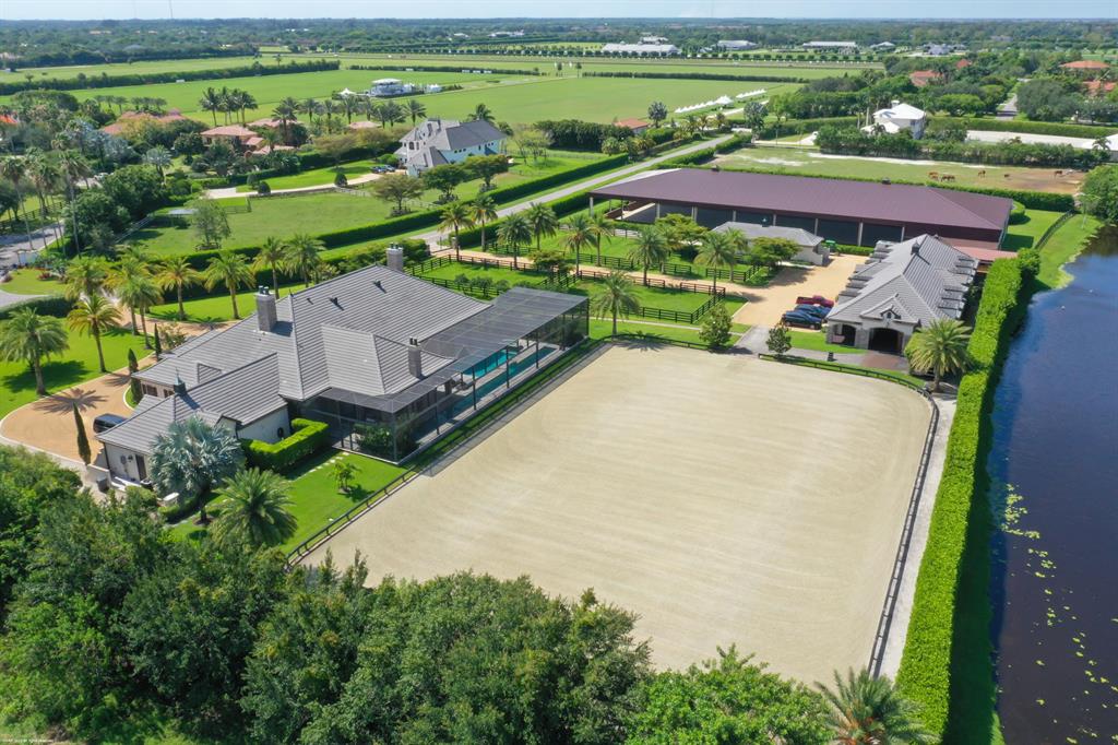 One of a kind equestrian estate on 5.54 acres with covered & outdoor riding arenas & a 17 stall center-aisle barn! Situated in a prime location close to GDF & WEF, this property was designed for top equestrians. The 4Br main residence boasts: stone floors, a center-island kitchen w/gas cooking, wine cooler, walk-in pantry, impact window & doors, a stunning heated pool with lap lane, summer kitchen & outdoor gas fireplace. There is also a 1Br/1Bth guest house for family or staff. The impeccable stable features rubber pavers, feed, tack & laundry rooms, cross-aisle and covered walkway to the covered arena. Both arenas have ebb and flow watering systems with world class footing. There are 8 paddocks, a round pen and overflow outdoor wash racks. This property is move-in ready & a must see!