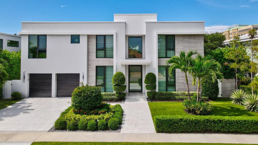 Situated in one of East Boca Raton's most coveted neighborhoods, this five-bedroom, five-and-a-half-bath contemporary estate lies just steps from Mizner Park and moments from the beach. Located in the heart of the Golden Triangle, this property offers unmatched walkability to Boca's top restaurants, shops, and cultural attractions—all while tucked into a quiet, tree-lined street. Inside, clean modern lines and walls of glass create a bright, airy feel throughout. A dramatic floating staircase beneath a glass skylight anchors the entry, setting the tone for bold, sophisticated living. The open-concept main floor features a sleek chef's kitchen with professional-grade appliances, a waterfall-edge bar, and spacious living and dining areas perfect for entertaining. Glass sliders open to a  private backyard oasis with a resort-style pool, integrated Jacuzzi, covered patio, and lush tropical landscaping. Upstairs, discover three en-suite bedrooms and a luxurious primary suite complete with spa-inspired bath, oversized walk-in closets, a morning bar, and floor-to-ceiling windows that bring the outside in. Additional features include a two-car garage, impact windows and doors, and smart home technology throughout. A rare opportunity to own a modern estate just a short stroll from downtown Boca's vibrant lifestyle.