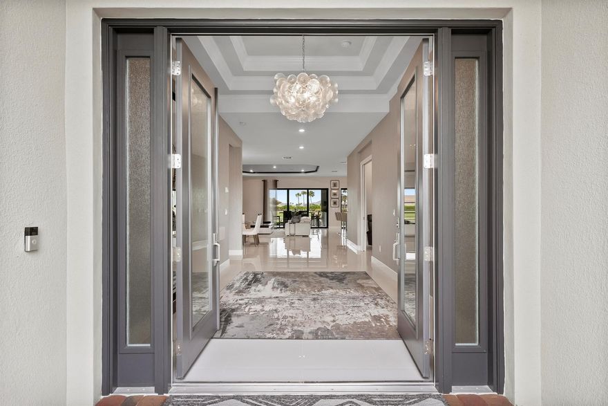 This Pallazio floor plan features extensive post-construction upgrades that go far beyond builder offerings. Offering 3 bedrooms, 3 bathrooms, plus a study/flex space, this exceptional home is situated on a quiet cul-de-sac on an oversized .36-acre pie-shaped lot that widens at the rear and overlooks a serene lake. Structural enhancements include an extended covered lanai, extended gourmet kitchen, outdoor kitchen gas and plumbing rough-ins, and extended bay windows in the primary suite. All impact windows and doors, paired with a brand-new barrel tile roof (2023), provide peace of mind and contribute to lower homeowners insurance rates. Inside, oversized porcelain tile flooring throughout (no carpet) creates a light, airy, and cohesive aesthetic. Professionally designed interiors take