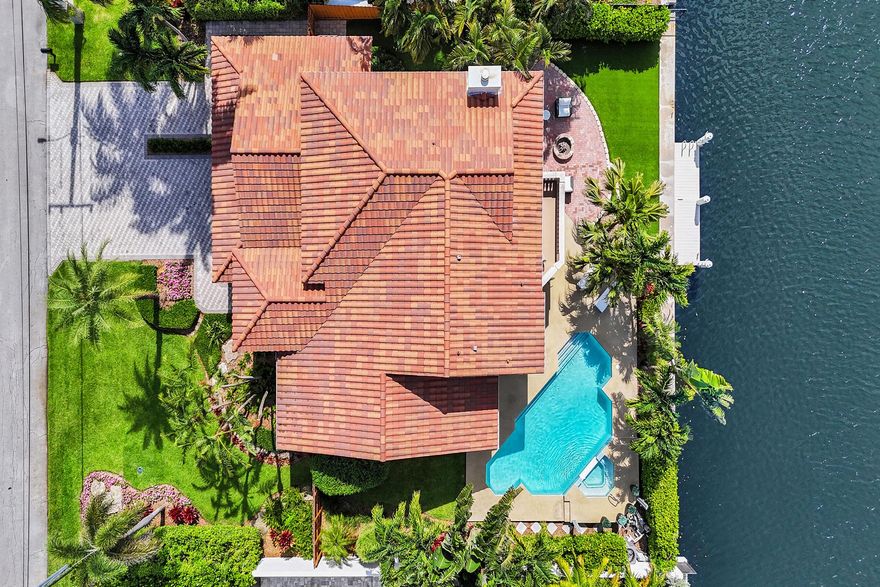 Discover your slice of paradise in this exquisite 4-bedroom, 3-bathroom, 3-car garage home, perfectly situated on 90' of prime waterfront in the highly sought-after Tropic Isles neighborhood of Delray Beach. Move-in ready and designed for luxurious Florida living, this residence combines modern elegance with enjoyable outdoor amenities. Marble floors flow throughout the first floor, complemented by an open-concept layout and soaring ceilings that create a spacious, airy ambiance. The state-of-the-art chef's kitchen boasts premium appliances, custom cabinetry, and sleek finishes, perfect for culinary enthusiasts and entertaining. Enjoy a heated swimming pool, covered patio, fire pit, and private dock, all set against captivating waterfront views ideal for relaxation or hosting guests.