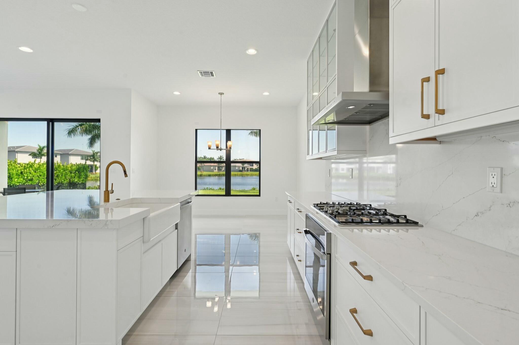 Brand New Lakefront Home | 5BD + Den | Designer Finishes Throughout. Stunning new construction home with expansive long lake views and premium upgrades throughout. This spacious 5-bedroom home showcases a rare his-and-her bathroom layout in the primary suite, paired with an oversized custom walk-in closet. Porcelain tile flooring flows seamlessly through the main level, complementing a chef-inspired kitchen with an apron-front sink, full backsplash, gas cooktop, and elegant gold hardware. All bathrooms feature luxury finishes and refined gold accents. Impact glass and a thoughtfully designed open floor plan blend elegance with everyday comfort, all within a community that truly has it all!