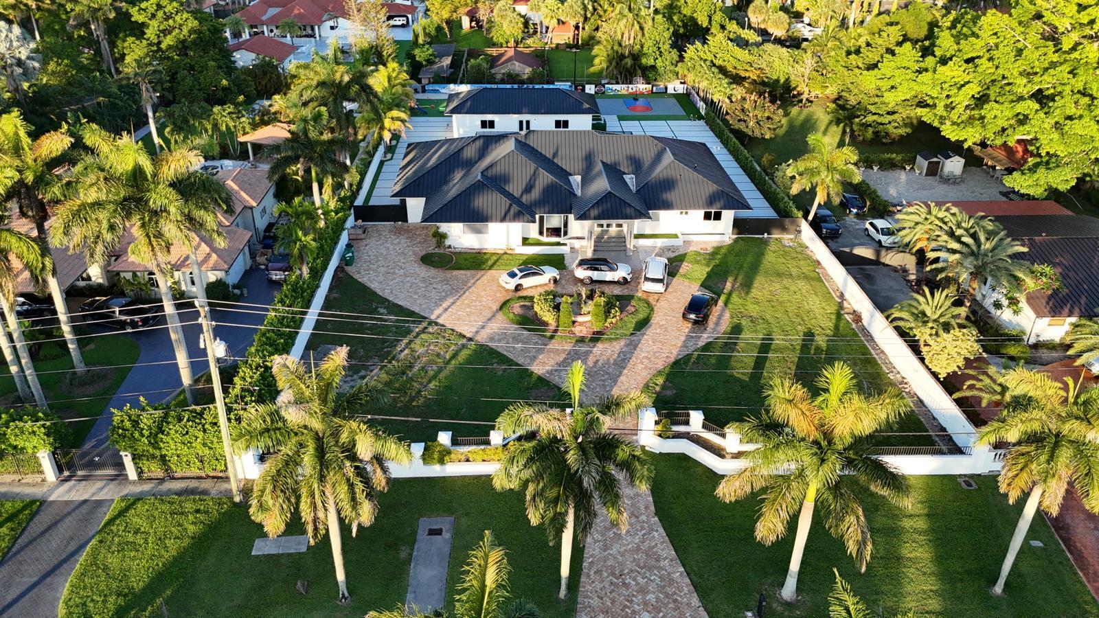 Stunning Mediterranean-style residence on nearly 1 acre, all on one level. This home features vaulted ceilings, a spacious primary suite, gourmet kitchen with island, and private wings with en-suite baths. Perfect for entertaining, it offers a sparkling pool and covered terrace. For sports and outdoor fun, enjoy your own basketball and beach volleyball courts. The circular driveway and grand porte-cochere provide ample parking with comfort and style. A truly unique home that combines elegance, recreation, and space in a prime Miami location.