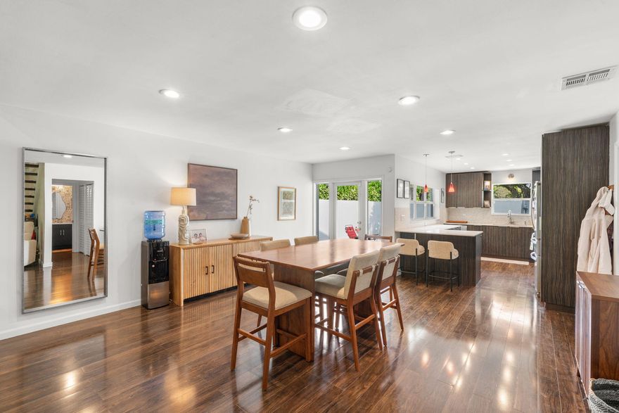 Welcome to this beautifully maintained end-unit townhome with a bright, open layout, vaulted ceilings, and abundant natural light. Laminate wood plank flooring enhances the spacious living area, featuring a striking fireplace wall and seamless flow into the dining space and kitchen with modern cabinetry, light countertops, stainless steel appliances, and bar seating. The primary suite offers vaulted ceilings and a well-appointed bath with a glass-enclosed shower and modern vanity. Enjoy a private covered patio with lush tropical landscaping. Recent improvements include roof (2021), AC (2023), and newer lighting and fans. Located within 2mi of Whole Foods, Publix, Target, LA Fitness, the beach, and I-95. 1% lender credit toward closing costs when using seller's preferred lender.