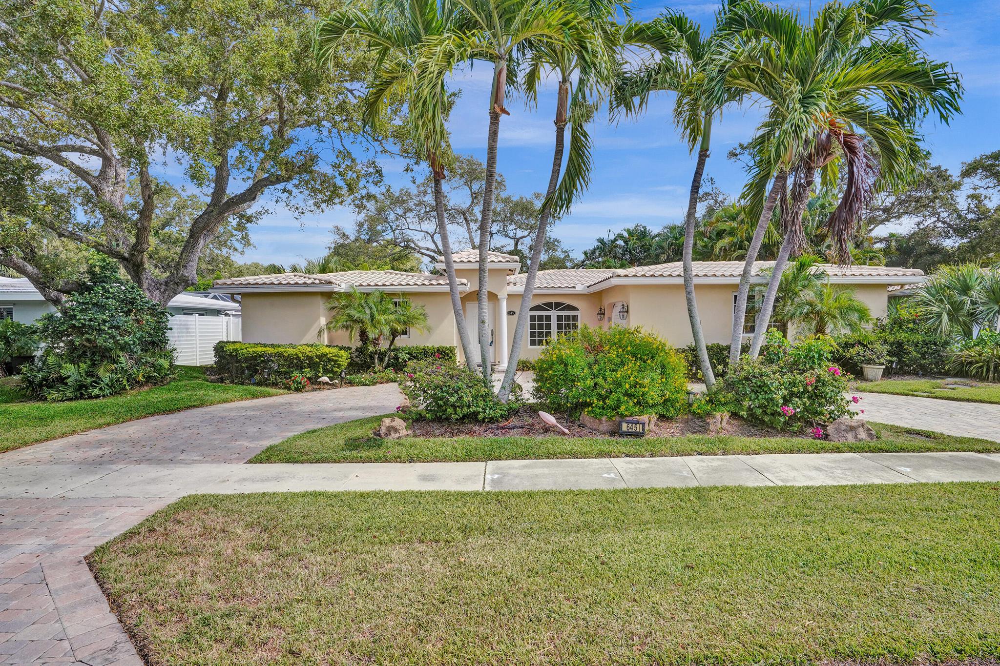 Prime location in East Boca. Updated open floor plan, split bedrooms. Large main bedroom with walk-in closet, large bath with lots of storage, separate a/c & tankless hot water. Custom cabinets in kitchen, granite counters/backsplash, stainless appliances & large island. Interior laundry with stacking washer/dryer, cabinets with granite countertop makes pantry or coffee bar. Impact windows & doors. French doors (with accordion shutters) open to a large covered/screened Florida room with tile floor (can easily be enclosed). Beautiful neutral tile in main living areas, crown molding, updated guest bath. Oversized 1 car garage w/ lots of storage. Circular paver driveway. Large private yard (partially fenced) lots of room for a pool. Tropically landscaped on a quiet street.