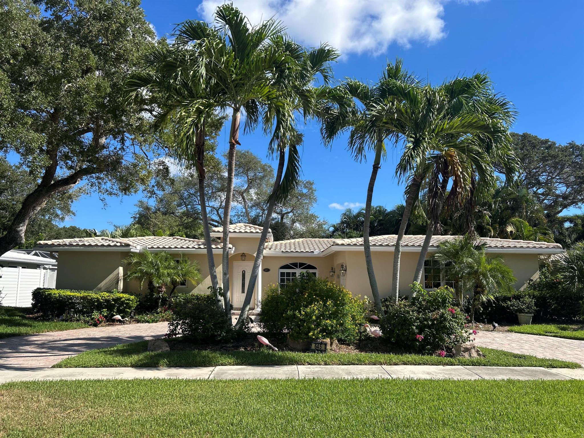 Prime location in East Boca. Updated open floor plan, split bedrooms. Large main bedroom with walk-in closet, large bath with lots of storage, separate a/c & tankless hot water. Custom cabinets in kitchen, granite counters/backsplash, stainless appliances & large island. Interior laundry with stacking washer/dryer, cabinets with granite countertop makes pantry or coffee bar. Impact windows & doors. French doors (with accordion shutters) open to a large covered/screened Florida room with tile floor (can easily be enclosed). Beautiful neutral tile in main living areas, crown molding, updated guest bath. Oversized 1 car garage w/ lots of storage. Circular paver driveway. Large private yard (partially fenced) lots of room for a pool. Tropically landscaped on a quiet street.