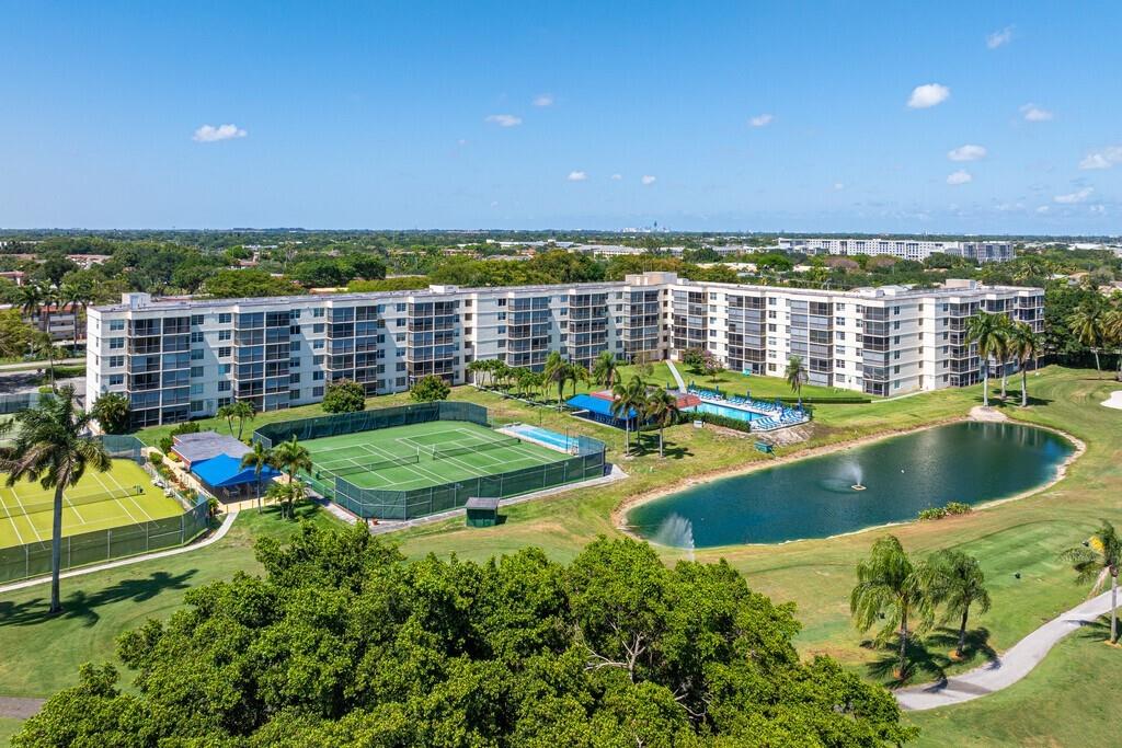 Live the resort lifestyle every day in this renovated 1-bed, 1.5-bath condo with den that can easily be used as a second bedroom. Located on the First Floor. Enjoy Stunning golf and lake views! Enjoy an open layout with granite countertops, wood cabinets, stainless steel appliances. Both bathrooms have been updated. Laminate and tile flooring throughout. Washer/dryer just steps away. Relax on the screened balcony to watch the sunset. Resort-style amenities include Golf (cart fee applies), heated pools, tennis, pickleball, gym, sauna, EV charging, billiards, library, BBQ areas, clubhouse, courtesy bus, cafe, carwash, 24/7 security and patrol. Conveniently located near shoppes, restaurants, highways, Gulfstream Park, Hard Rock and more!