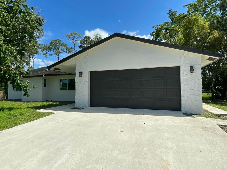 Beautifully updated 3BR/2BA home on 1.25 acres with peaceful canal frontage. Freshly painted inside and out, featuring a split floor plan, impact windows and doors, and a 200-amp Leviton electrical panel with smart app access. Enjoy a screened patio overlooking a fully fenced yard with electric gate—perfect for relaxing or entertaining. Major upgrades include a new water heater and regularly maintained water system. Zoned Agricultural Residential, offering room for gardening, animals, or added space to grow. Ideally located near Loxahatchee, Royal Palm Beach, and Palm Beach Gardens—combining privacy, convenience, and modern living. Welcome to this beautifully updated 3-bedroom, 2-bath home offering the perfect blend of space, privacy, and modern convenience. Freshly painted inside and out, this move-in-ready residence features a desirable split floor plan designed for both everyday comfort and effortless living.  Step inside and enjoy peace of mind with impact windows and doors, along with upgraded electrical including a 200-amp Leviton panel with smart app access—bringing safety and convenience together.  The outdoor space truly sets this property apart. Relax or entertain on the screened-in patio overlooking a sprawling, fully fenced half-acre lot with tranquil canal frontage. Whether you envision weekend gatherings, gardening, or simply enjoying the quiet surroundings, this property delivers.  Zoned Agricultural Residential, this property offers rare flexibility—perfect for those seeking a rural lifestyle with the ability to garden, farm, or keep animals, all while enjoying the comforts of a well-appointed home.  Ideally located with easy access to Loxahatchee, Royal Palm Beach, and Palm Beach Gardens, you'll enjoy the best of both worlds: peaceful, open living with nearby conveniences.  Space, upgrades, and lifestyle—this is more than a home, it's an opportunity.