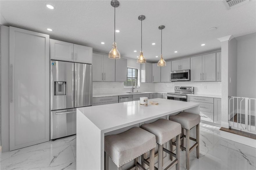 Impressive 3 bed 2.5 bath spacious townhome. Modern designs all through out, starting from the Quartz Kitchen Countertops, A sizable Waterfall Edge Island with endless amount of cabinets to complete this beautiful kitchen. 24x48 Porcelain tile on 1st floor, with an open concept to the family and dinning areas. The first floor accommodates a half bath, along with separate room for the laundry and extra storage. Natural Stacked Stone design on staircase wall, Water resistant laminate floors on the staircase & entire 2nd floor, All updated bathrooms, Crown Molding all though out, Bamboo wall panel in living room, Adjustable recess lighting, Cable Railing on 2nd floor. Built in closet systems in bedrooms. Hurricane accordion shutters. Private fenced patio. Fantastic location! Reserved parking space numbers #5 and #6 in front of Townhome.