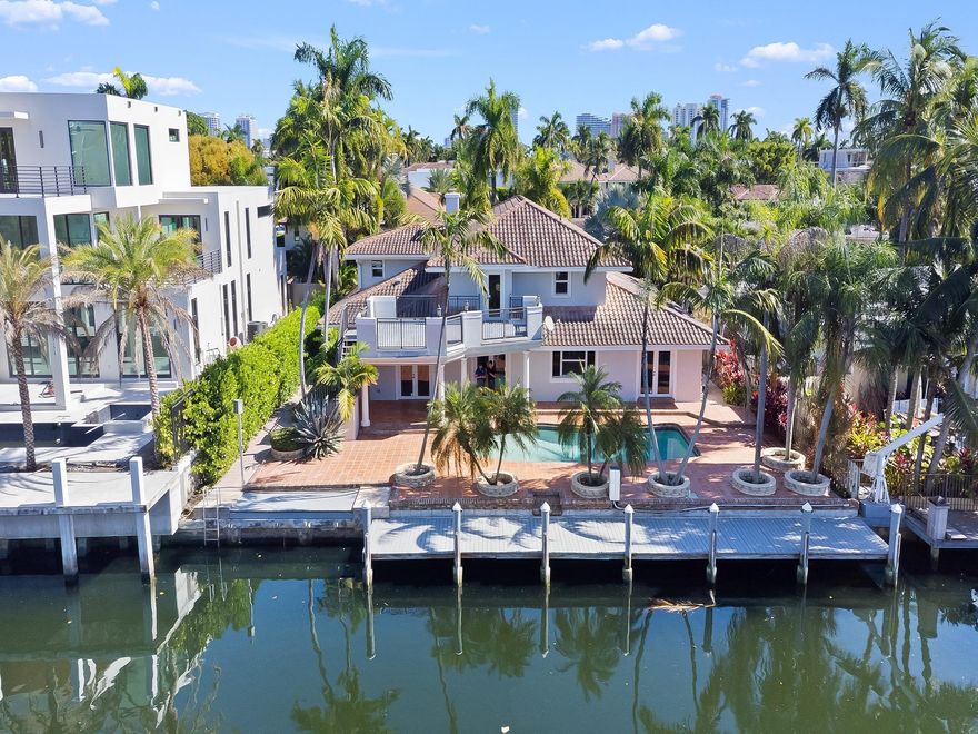Located on coveted Fiesta Way, with direct ocean access, this jewel with 87 ft. on the water and no fixed bridges, offers a unique blend of luxury, location and the Las Olas lifestyle - rarely found at this price. Through the double door entry is the 2 story living room with abundant natural light. The Chef’s Kitchen offers a large gas range, double ovens, ample prep space, and bar seating connected to the poolside family room. The first-floor primary suite overlooks the pool and canal, featuring a private sitting area, large custom closet & spa-like bath with dual vanities & soaking tub. The second floor guest suites are complimented by a large terrace overlooking the water. 103 Fiesta Way checks every box! For outdoor dining, sunning, boating, a walk to Las Olas Blvd or to the beach.