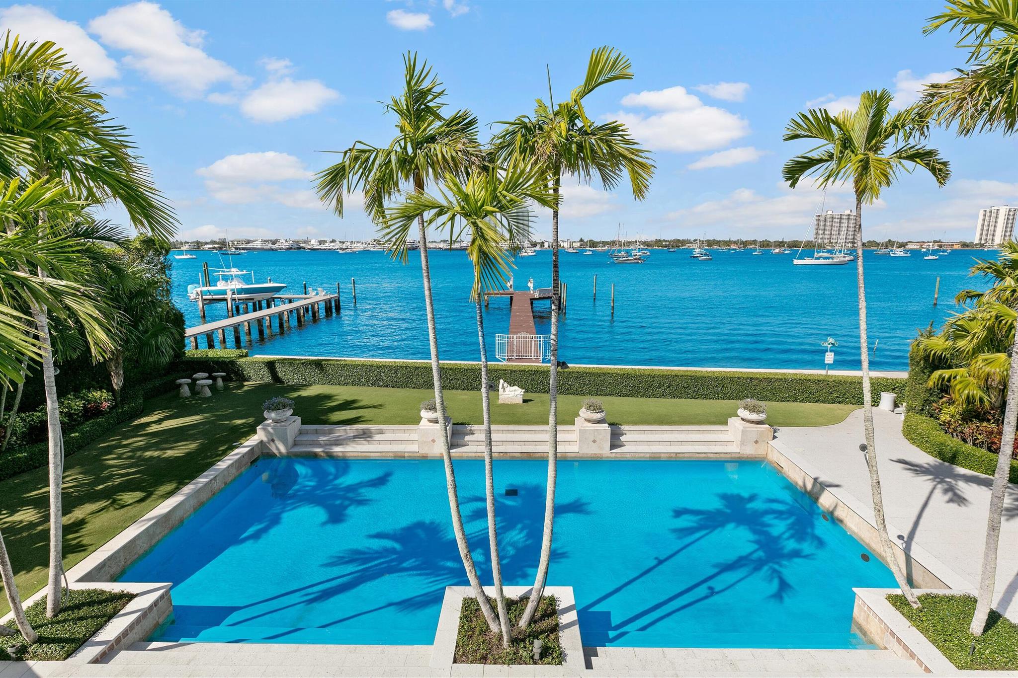 Stunning Contemporary Regency with dramatic views of the Intracoastal waterway and the motor yachts at Rybovich Marina. Excellent open floor plan perfect for indoor and outdoor entertaining. Features gracious living room, formal dining room, sunny and bright interior loggia. Family room with entertaining bar and office with beautiful views of the lake. Elevator leads to expansive second floor primary suite with sprawling, oversized terrace and dual baths. Additional highlights include chef's kitchen, staff bedrooms, and 2-car garage. Beautiful outdoor spaces with pool, Intracoastal dock, and access to the Lake Trail.