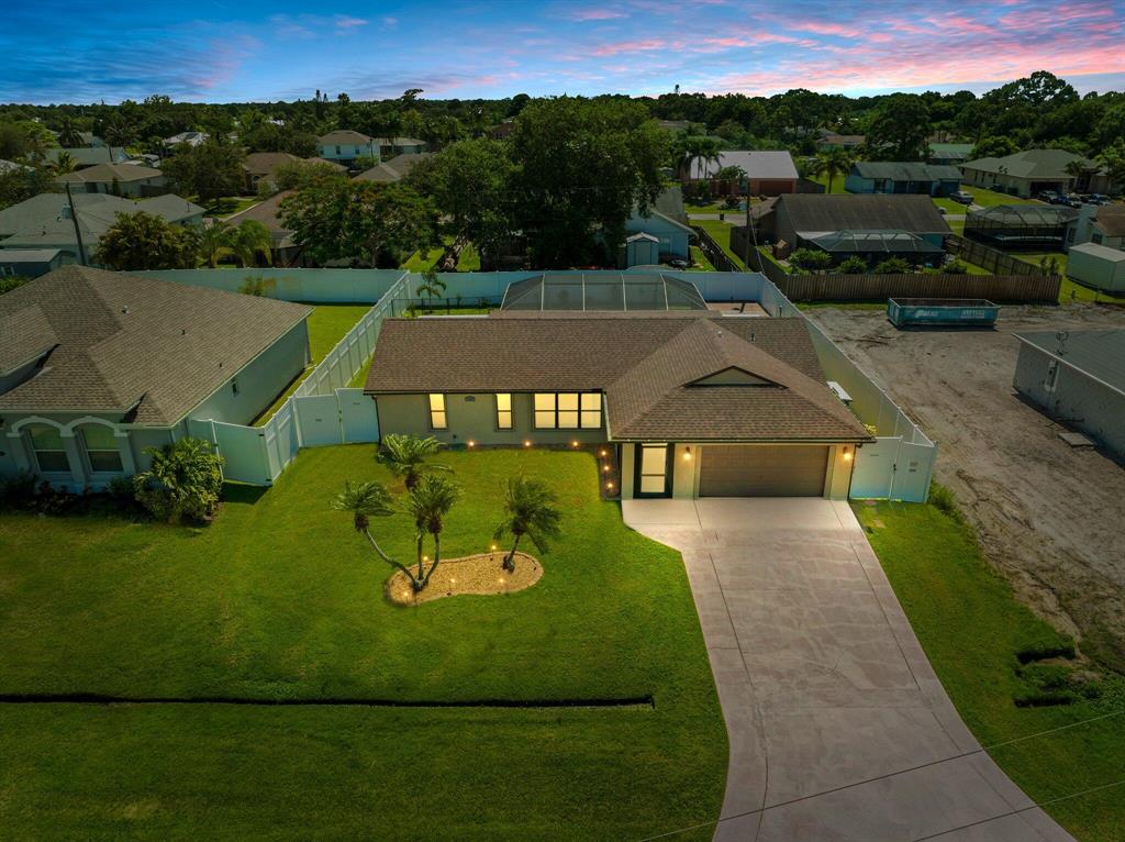 Welcome home to this cozy 3/2/2 CBS pool home situated in the heart of Port St Lucie, FL. Conveniently located across the street from a beautiful pond. This home has tons of recent upgrades including a brand new retrofitted roof complete w/ water barrier & gutters, new garage door, and new accordion shutters on every opening. The expansive backyard features all new landscaping, a screened-in pool, covered lanai, 2 decks, a fire pit, and a dog run. Additional upgrades include a new 8 foot vinyl fence that allows for total privacy while you entertain your guests. Inside you will find new carpet in the bedrooms, new hot-water heater, new washer & dryer, new ceiling fans, new toilets, new appliances, and freshly painted interior. This peaceful neighborhood is located near shopping