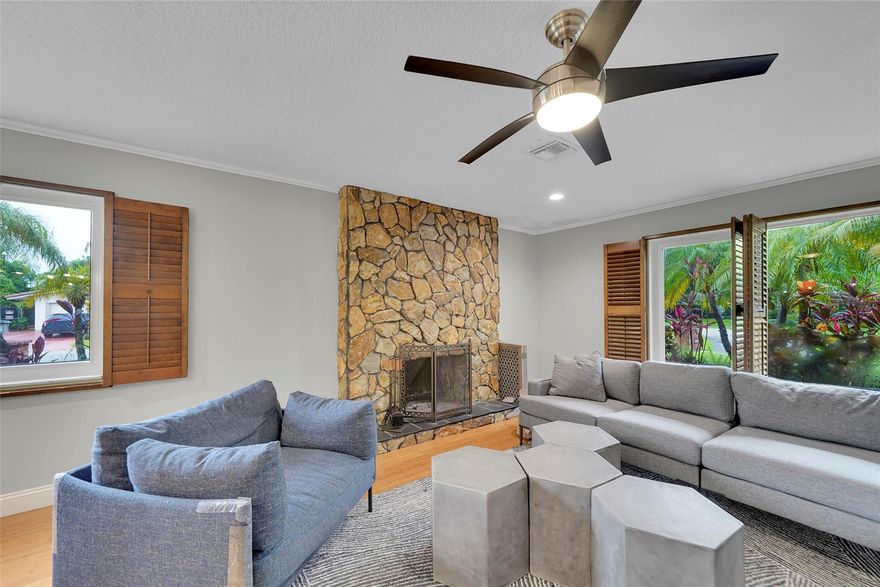 Welcome to this spacious home offering exceptional curb appeal and functionality, featuring two driveways, a large circular driveway in front and a side driveway leading to a 2-car garage. Perfect for guests, multi-vehicle households, or added convenience. Step inside to a home filled with natural light and enhanced by impact windows throughout. The inviting front living room showcases elegant plantation shutters and a working wood-burning fireplace, creating a warm and welcoming space for relaxing or entertaining. The home also includes a versatile bonus room, ideal for a home office, den, or flex space, along with a full-size washer and dryer for everyday ease. Wine Cooler in Kitchen. Outdoors, enjoy your private retreat with a saltwater pool. Conveniently located near places of worship.