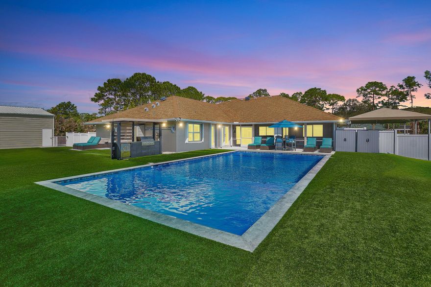 Over $350K in improvements in the past 2 years; 2026 NEW ROOF, 2025  CONCRETE driveway with plenty of space for RV, boat, and or multiple vehicles, FULL house storm accordion shutters, New driveway entrance gate, Full house peroxide water system, 2024 - New saltwater pool with heat/chill pump, Over 12k sq ft artificial grass providing minimal maintenance and always green, Sunshade sails - Side yard canopies, 2nd driveway access and culvert, Full sod irrigation with separate well. WELCOME HOME! This well-appointed estate home is resting on a premium 1.14-acre lot and includes all of the amazing features below and more! 2 primary suites with walk-in closets, 3 additional bedrooms plus an extra room, 3 full bathrooms, plus a half bath by the pool, 2 water heaters, 2 HVAC units (CLICK) with split temperature control, 24KW whole house generator with 500-gallon propane tank, 2 car attached garage, 720 sq ft detached garage workshop, Fully fenced property, Full house water softener, Outdoor kitchen with 36" grill, rotisserie backburner, and a mini fridge, Multiple smart devices: driveway entrance gate, locks, thermostats, fans, irrigation, pool, Side yards protected by toad busters! No HOA and Nearby: 1 mile: grocery, dentist, Walgreens, gas, restaurants, 3 miles: gym, grocery, barber, hair salon, nails, coffee, gas, restaurants, veterinary, Emergency Room, and XCEL pickle ball. OPEN HOUSE MAY 16TH 2:00 - 4:00