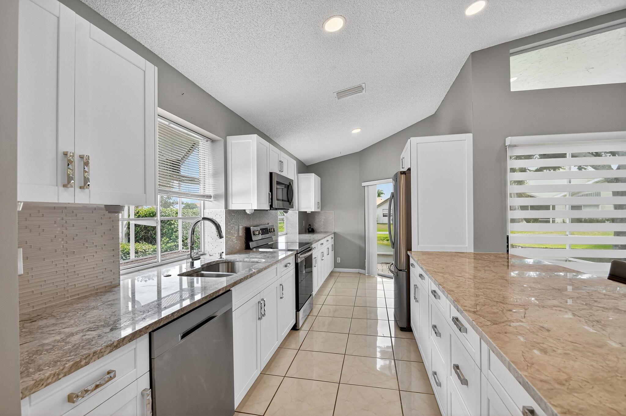 Welcome home to this Beautiful 3 bed, 2 bath lakefront home in the fabulous low HOA 55+ community of LAKERIDGE! Enjoy the stunning kitchen w/ granite counter tops, glass tile back splash, white cabinetry & stainless appliances. The extended roofed screened patio looks over the serene lake, perfect for entertaining, or enjoying quiet moments. Primary suite boasts dual sinks, soaking tub and separate shower as well as access to patio. The home boasts tile floors throughout living areas, laminate in bedrooms. Roof 2018, water heater 2024. Den/3rd Bedroom has double glass doors. Don't miss this move-in ready gem in an active, amenity-rich neighborhood!