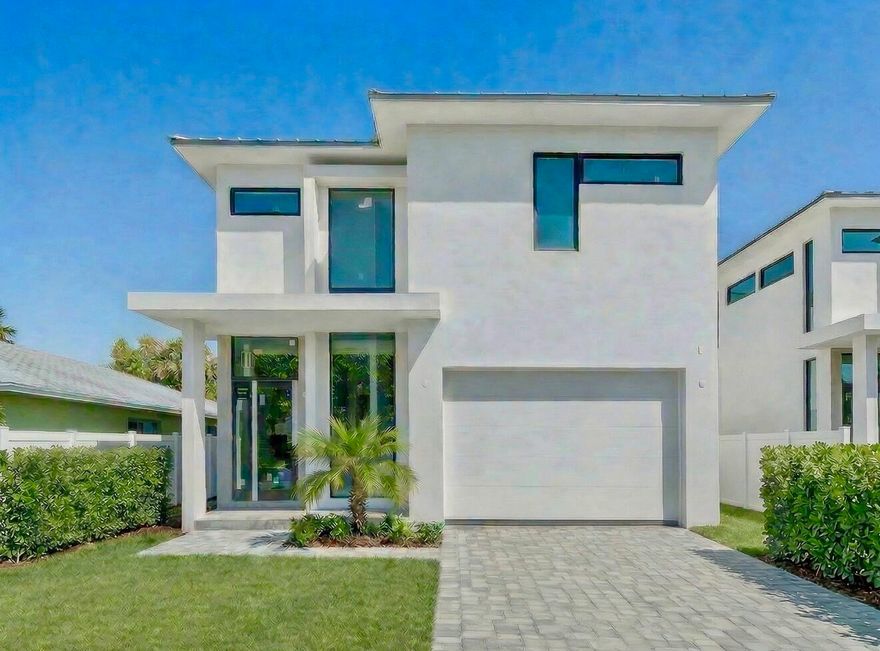 A striking expression of modern design, this newly constructed residence by Marc Julien Homes offers a seamless blend of architecture, light, and livability in one of East Delray Beach's hottest in-town locations - Osceola Park. Encompassing 3,223 square feet under air, this thoughtfully designed two-story home delivers clean lines, expansive glass, and a true indoor-outdoor lifestyle.  From the moment you enter, a dramatic two-story foyer sets the tone, filling the home with natural light and volume. The open-concept living, dining, and kitchen spaces flow effortlessly, enhanced by oversized dual stacking sliders that extend to the private backyard—creating a seamless transition to the covered outdoor living area and saltwater pool with sun shelf.   The designer kitchen serves as the centerpiece of the home, featuring custom two-toned cabinetry, quartz countertops and full backsplash, and a large waterfall-edge island ideal for both everyday living and entertaining. A premium Fisher & Paykel appliance package, including a 36" induction range, integrated refrigeration, and high-performance ventilation, completes the space. A stylish wet bar with wine refrigeration and open shelving adds an additional layer of sophistication.  The first floor also offers a private den or office, a well-appointed powder bath, and refined finishes throughout, including large-format porcelain tile flooring and linear diffusers that enhance the home's modern aesthetic.  Upstairs, the primary suite is a true retreat, complete with floor-to-ceiling glass, a Juliette balcony, dual walk-in closets, and a spa-inspired bath featuring a freestanding soaking tub, walk-in shower, dual floating vanities, and designer finishes. Two additional en-suite bedrooms and a full laundry room provide both comfort and functionality.  Outside, professionally designed landscaping, privacy fencing, and a paver driveway complement the home's clean architectural lines and modern curb appeal. A standing seam metal roof and full hurricane-impact glass offer both durability and peace of mind.  Ideally located in Osceola Park, a darling of the developer set, on a quiet residential street just minutes from Atlantic Avenue, the beach, and Delray's renowned dining and shopping, this exceptional residence represents the best of contemporary coastal living, just 5 blocks from the heart of it all....park your car and live that chic coastal in-town lifestyle.    ***Developer's fee of 1.5% payable by buyer at closing.   The information published and provided including but not limited to prices, measurements, square footages, lot sizes, features, finishes, and calculations are subject to errors, omissions or changes without notice.  All such information should be independently verified.  All parties should perform their own due diligence to verify all information.