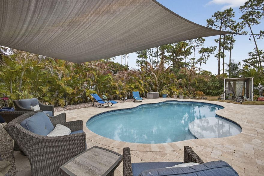 Beautiful 3-bedrooms, 2-full bath home situated on 1.15 acres in The Acreage, West Palm Beach-No HOA! This well-maintained property offers approximately 1800 total square feet and features tile flooring throughout. Enjoy outdoor living with a screened-in patio. Gorgeous heated, salted pool built 2018 with luscious greenery all around. Major updates include a 2016 roof, impact window installed in 2026 and a new A/C system replaced in 2021. The home also features new kitchen appliances and a newer washer and dryer. The spacious primary suite includes a newly renovated bathroom. Detached 6-car air conditioning garage provides ample space for vehicles, storage or workshop needs. Bring your boats, RVs, and toys-plenty of room to roam on this beautiful property. Come see this lovely home today!