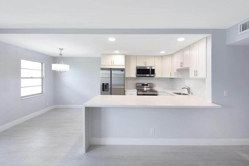 First floor unit that has been completely renovated from top to bottom. This unit has beautiful all white soft close cabinets with a Lazy Susan system in the corner cabinet, stainless steel appliances, a garbage disposal, an all white quartz counter with a backsplash, and waterfall porcelain wood look Brazilian floors throughout. The seller installed brand new hurricane impact sliding doors, and one window with hurricane slider so you have an even better lake view. Plus the master bedroom has a master bathroom connected to it that other units do not have. Both bathrooms have floating vanities, new toilets, custom shower, with frameless glass door. This unit truly has everything and more! An absolute must see if you are looking to get the most out of your Century Village experience.