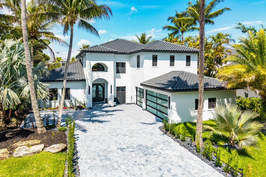 Completely renovated luxury residence in The Oaks of Boca Raton with stunning wide lake views. This turn-key home has been fully upgraded with no detail overlooked, including a new 2025 roof, 2026 HVAC systems, 2026 electrical panel, impact windows and doors, impact glass garage doors, and a new water heater.  The interior features modern 48x48 tile flooring throughout, a custom modern staircase, full electric window treatments, and a sleek contemporary design. The chef's kitchen is equipped with Sub-Zero and Wolf appliances, double Cove dishwashers, an oversized island with dual sinks, and Taj Mahal natural marble countertops.  Additional highlights include an onyx marble wine cellar, custom built-in library cabinetry, designer TV wall, and a modern office.  The primary (master) bathroom showcases XL slab tile walls and a spa-like design, complete with a smart electric toilet. The office bathroom features a unique onyx marble vanity.  Outdoor living is exceptional with a brand new pool and spa with WiFi control, marble pool deck, outdoor kitchen, automatic patio screens, and professionally designed new landscaping, all overlooking a beautiful lake.  The property also includes a 3-car garage with epoxy flooring and a custom iron impact front entry door.  Located in The Oaks, a premier gated community offering resort-style amenities including clubhouse, restaurant, fitness center, tennis courts, spa, and 24/7 security.  A rare opportunity to own a fully modernized luxury home in one of Boca Raton's most desirable communities.